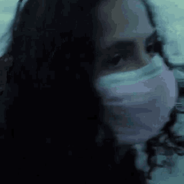 a close up of a woman wearing a mask