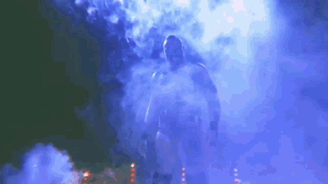 a man is standing in a dark room surrounded by smoke
