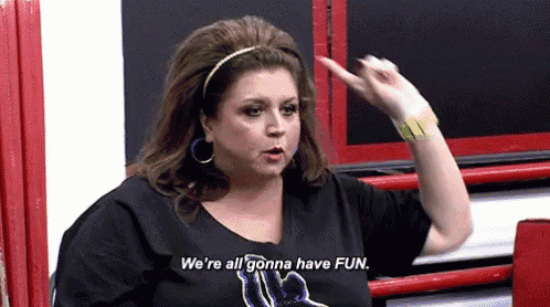 a woman is wearing a black shirt and saying `` we 're all gonna have fun . ''