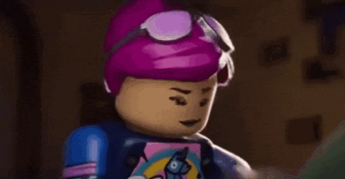 a lego girl with pink hair and goggles is wearing a unicorn shirt .