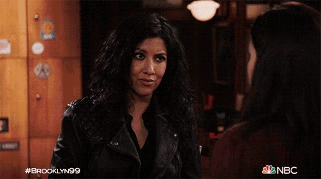 two women are laughing at a bar with a brooklyn99 logo