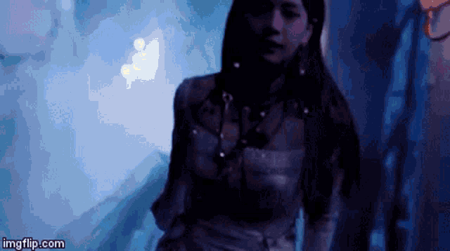 a woman is standing in a dark room in a dark room .