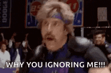 a man in a purple jacket and headband is talking into a microphone and says `` why you ignoring me !! ''