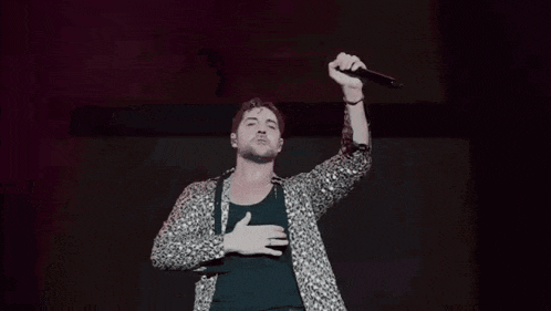 a man singing into a microphone on stage