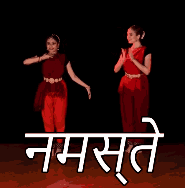 two women are dancing in front of the word namaste