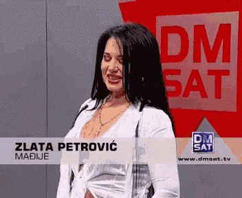 a woman stands in front of a dm sat sign
