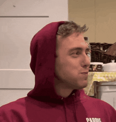 a man wearing a red hoodie that says carrie on the front