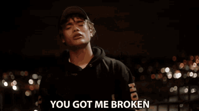 a young man wearing a hat and a hoodie says " you got me broken "