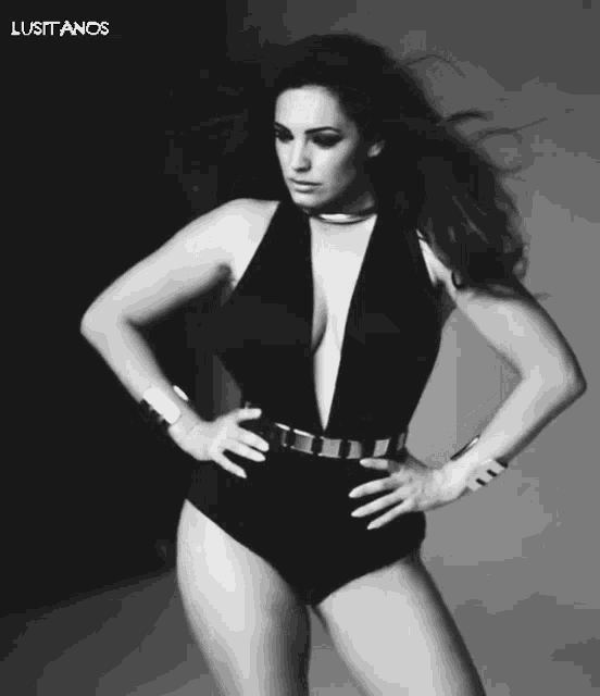 a black and white photo of a woman in a plunging black swimsuit with the words lusitanos below her