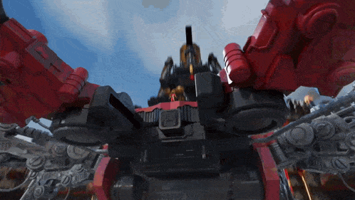 a red and black robot with a person standing on it