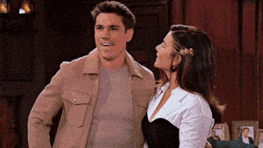 a man and woman are standing next to each other in a living room