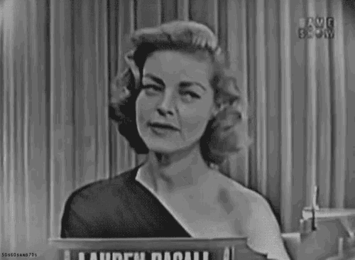 a black and white photo of a woman standing in front of a sign that says lauren bacall .