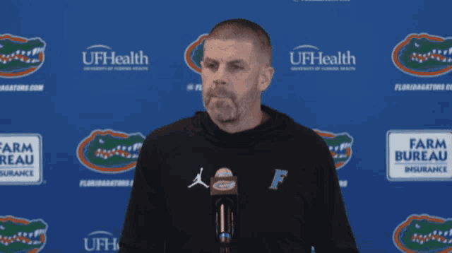 a man stands in front of a blue wall that says ufhealth
