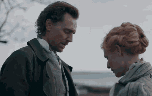 a man and a woman are looking at each other with a blue sky behind them