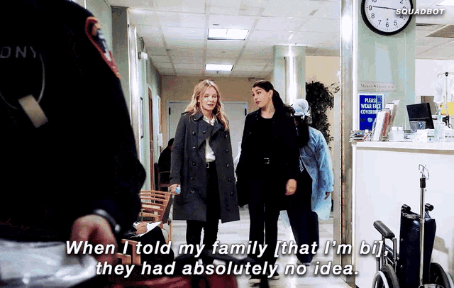 two women are walking down a hallway with a clock on the wall that says squadbot