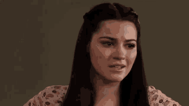 a woman with long hair is making a funny face while looking at the camera .