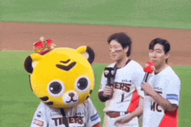 a mascot wearing a crown is standing next to two baseball players on a baseball field .