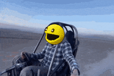 a man in a plaid shirt is driving a buggy with a pac man face on his face