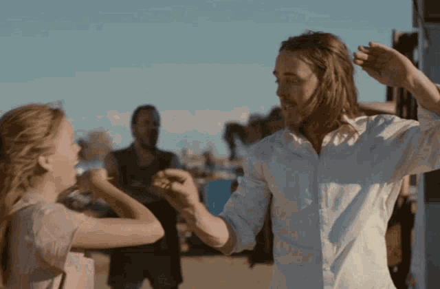 a man in a white shirt is dancing with a young girl