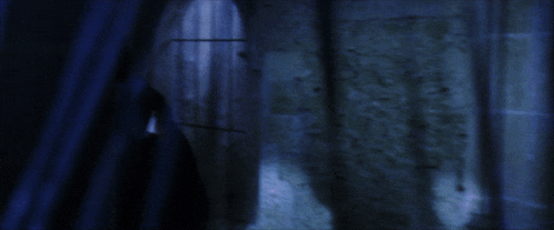 a dark room with a blue curtain and a brick wall