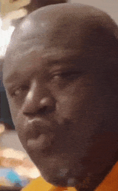 a close up of a man 's face with a yellow shirt on