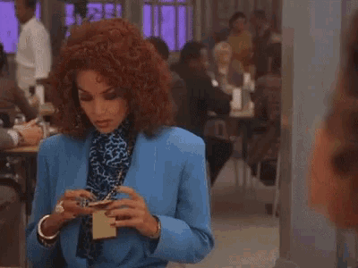 a woman in a blue suit is holding a name tag in her hand .