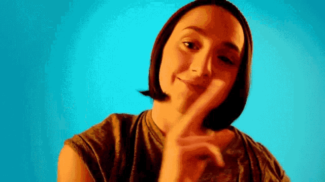 a woman is making a funny face with her finger on her lips