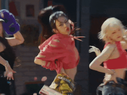 a group of young women are dancing in front of a record shop