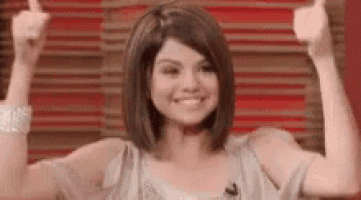 a woman is smiling and giving a thumbs up sign .