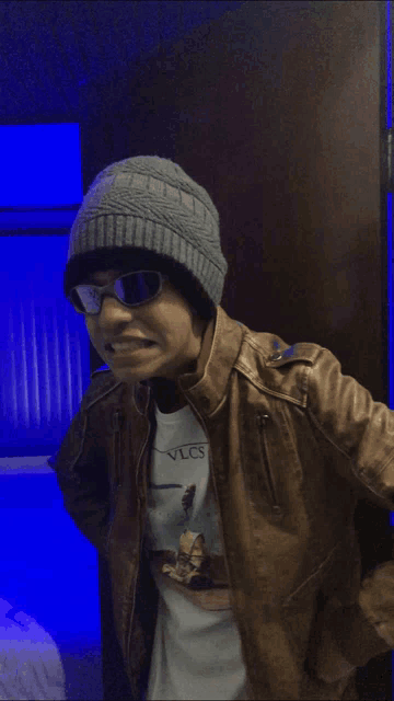 a man wearing sunglasses and a beanie has a shirt that says vlcs