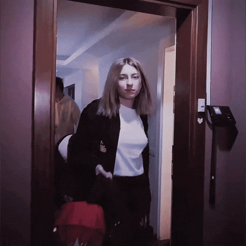 a woman standing in a doorway with a heart shaped sticker on the wall