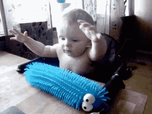 a baby is sitting in a high chair playing with a blue stuffed animal