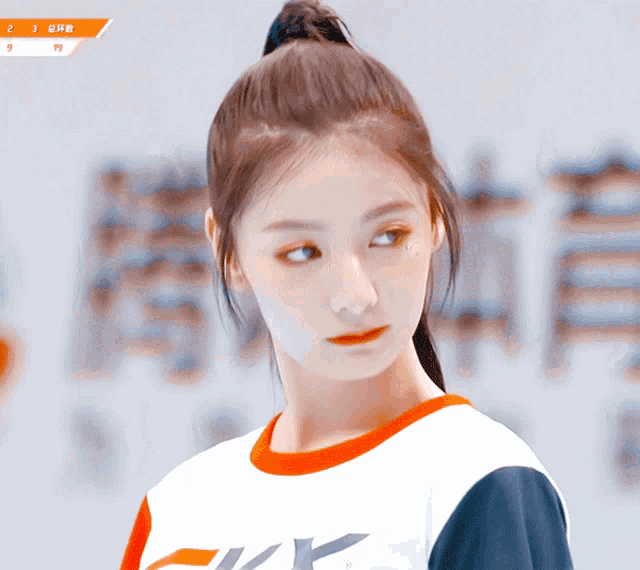 a girl with a ponytail is wearing a shirt that says ' yk ' on it