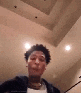 a young man is making a funny face while standing in a room .