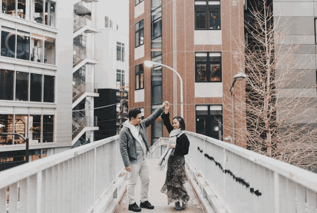 a man and a woman are holding hands on a bridge in front of a starbucks coffee shop