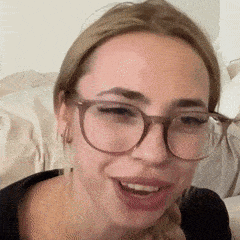 a close up of a woman wearing glasses and smiling