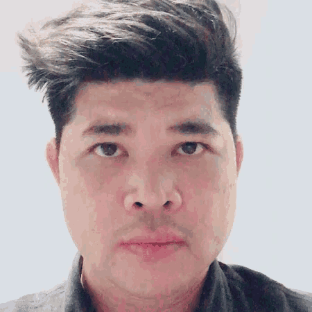 a close up of a man 's face with a gray shirt