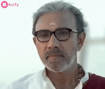 a man with a beard and glasses is wearing a white shirt and a red scarf .