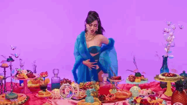 a woman is standing in front of a table full of food .