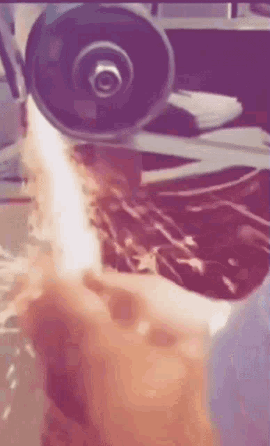 a person is cutting a piece of metal with a circular saw