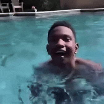 a man is swimming in a pool and smiling at the camera