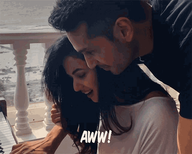 a man and a woman are hugging with the word aww on the bottom right