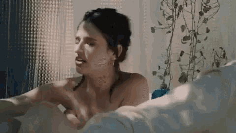 a naked woman is taking a bath in a bathtub .