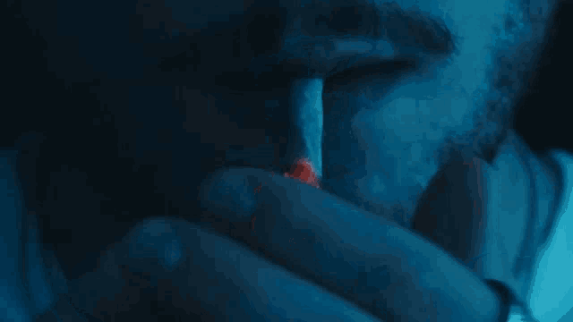 a close up of a person smoking a cigarette