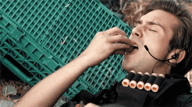 a man is wearing a headset and eating a sandwich