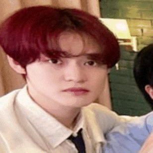 a close up of a young man with red hair making a funny face .
