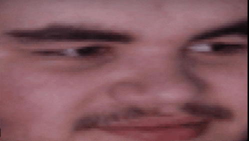 a close up of a man 's face with a mustache