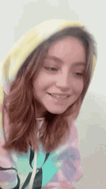 a close up of a woman wearing a hoodie and a hat .