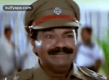a man with a mustache is wearing a police uniform and hat and smiling .