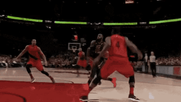 a group of basketball players are playing a game of basketball and one of them has the number 4 on his jersey